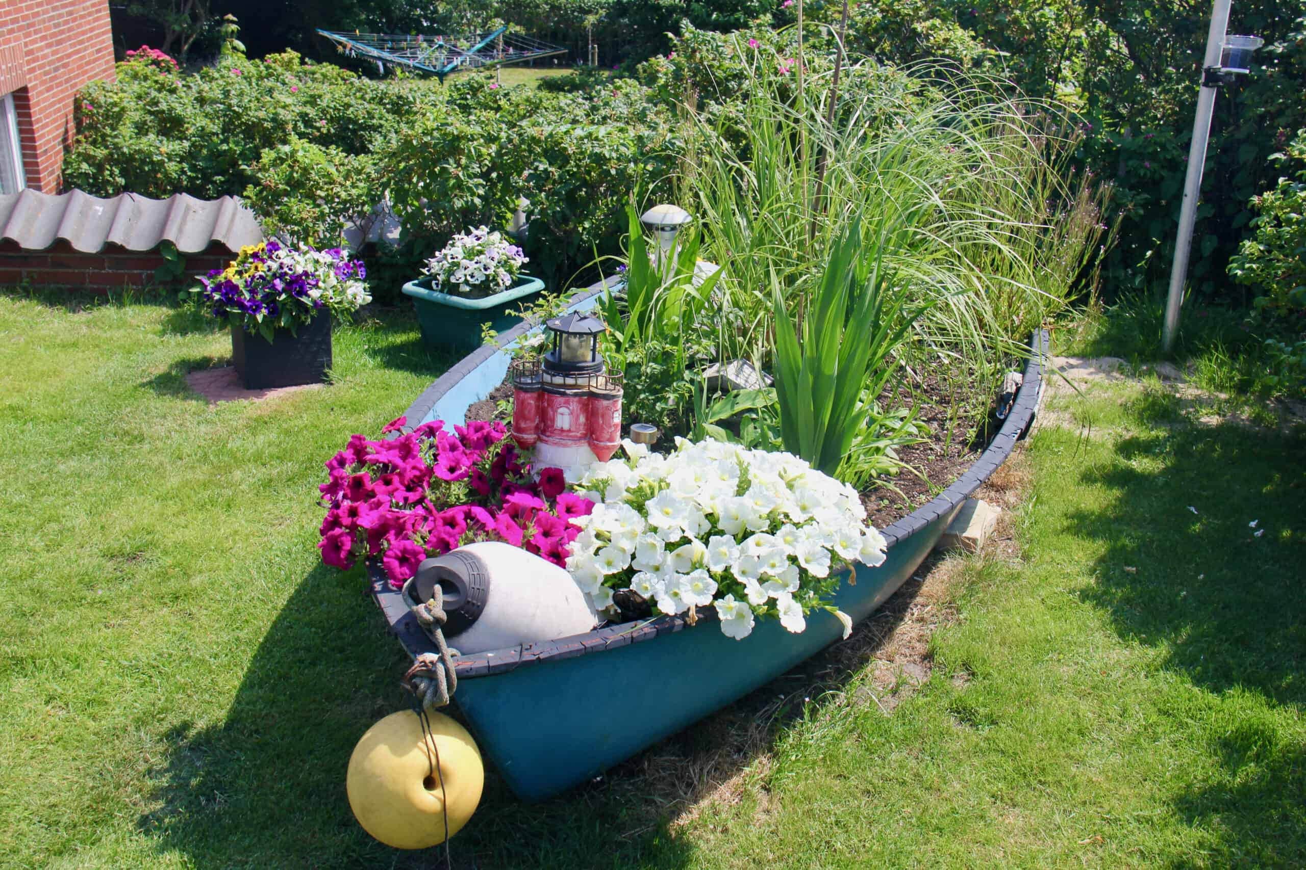 Deko-Ruderboot als Blumenbeet im Garten