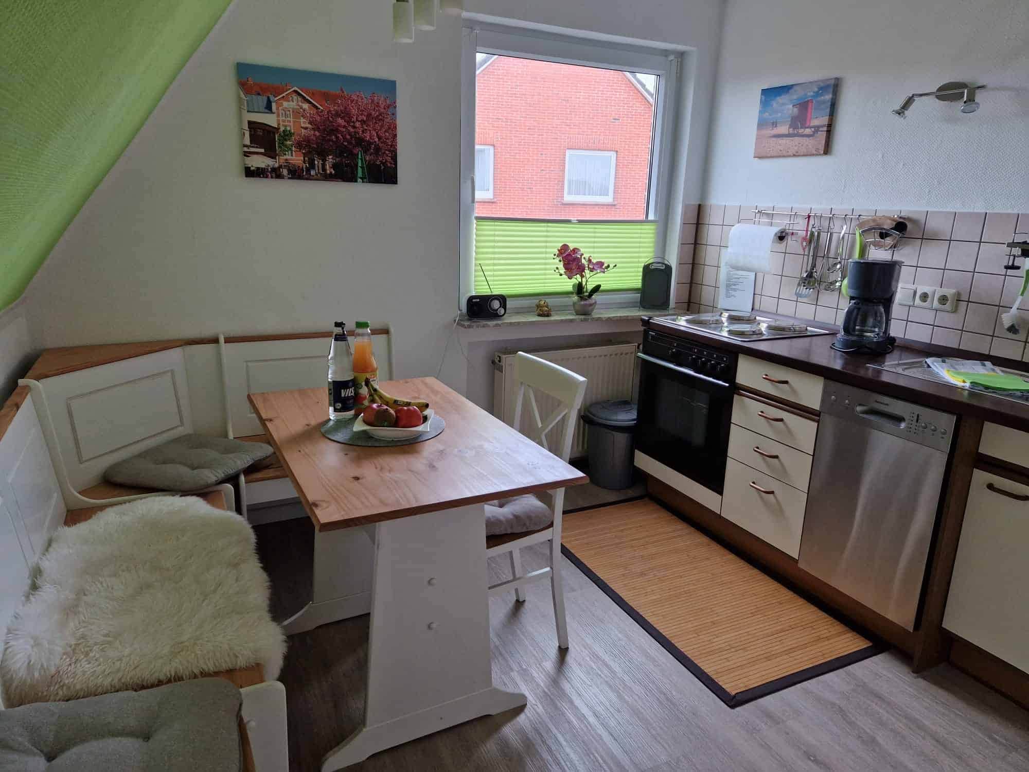 Küche mit Eckbank, Herd, Spülmaschine und Kühlschrank