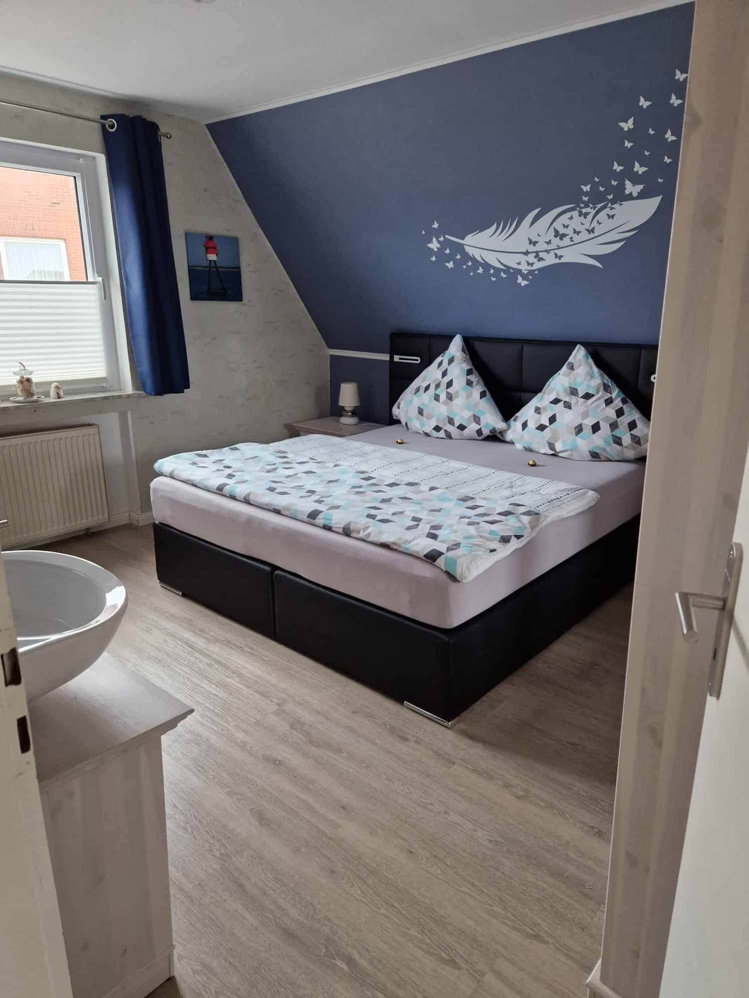 Schlafzimmer mit Doppelbett und Feder-Wandtattoo