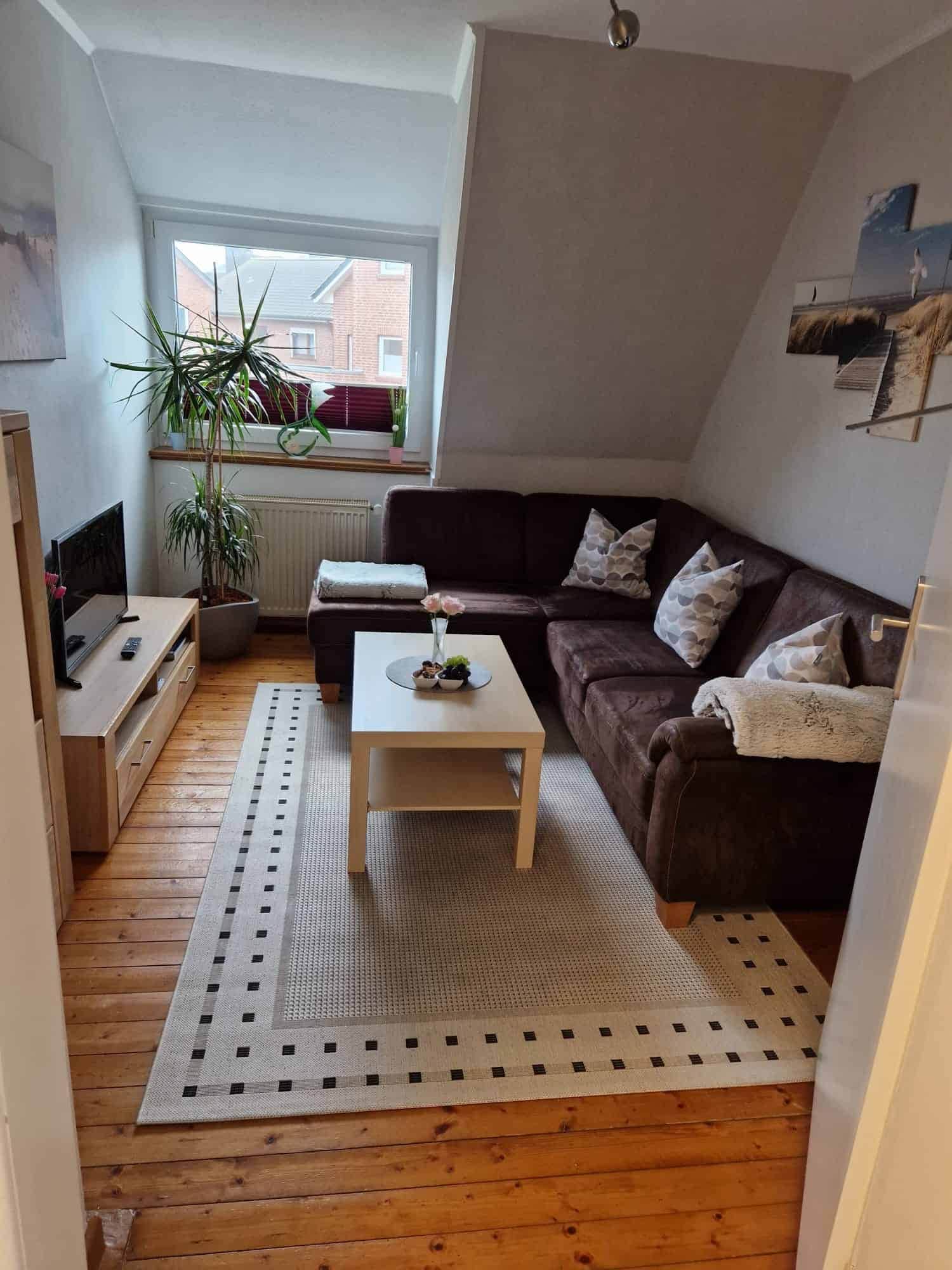 Wohnzimmerecke mit brauner Ledercouch und Fernseher