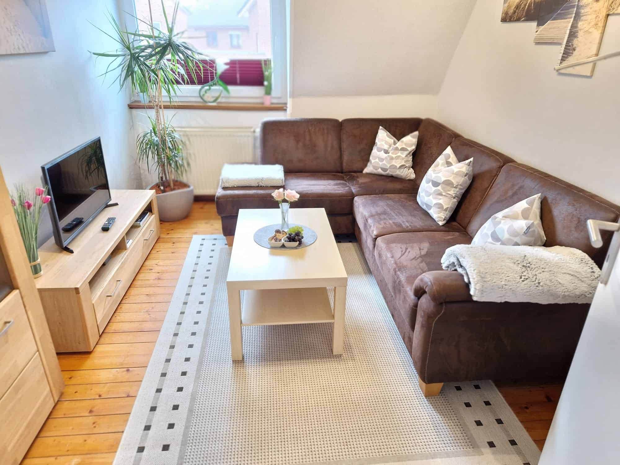 Gemütliches Wohnzimmer mit brauner Couch und Couchtisch